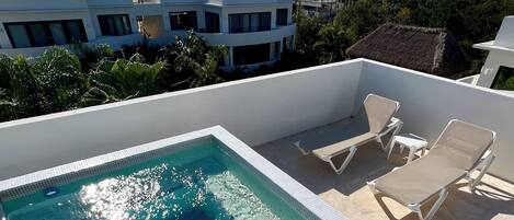 Una piscina al aire libre, sillones reclinables de piscina