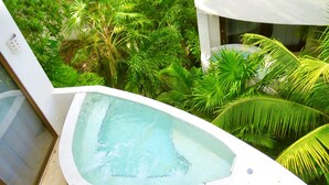A hot tub with a tiled edge, surrounded by lush greenery. - Adults only Resort in Tulum (Tulum)