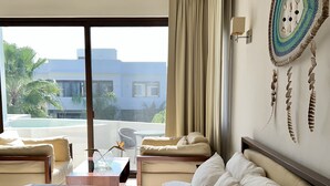 A hotel room with a large bed, a ceiling fan, a view of the outdoors, and a decorative wall hanging. - Adults only Resort in Tulum (Tulum)