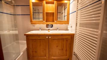 Ein Holzbadezimmer-Möbelstück mit zwei Waschbecken, einem Spiegel und einer Duschkabine.