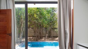 A bedroom with a view of an outdoor swimming pool surrounded by trees. - Carpediem - Casa Luxuosa em Pipa (Tibau do Sul)