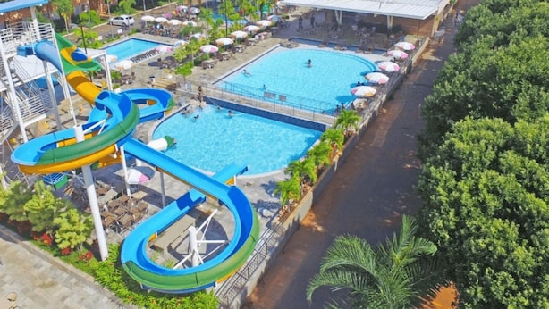 A water park with multiple pools and a large water slide. - Aptos - DiRoma Fiori - Aluguel Economico (Caldas Novas)