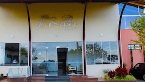 A building with a glass facade and a sign above the entrance. - Aptos - DiRoma Fiori - Aluguel Economico (Caldas Novas)