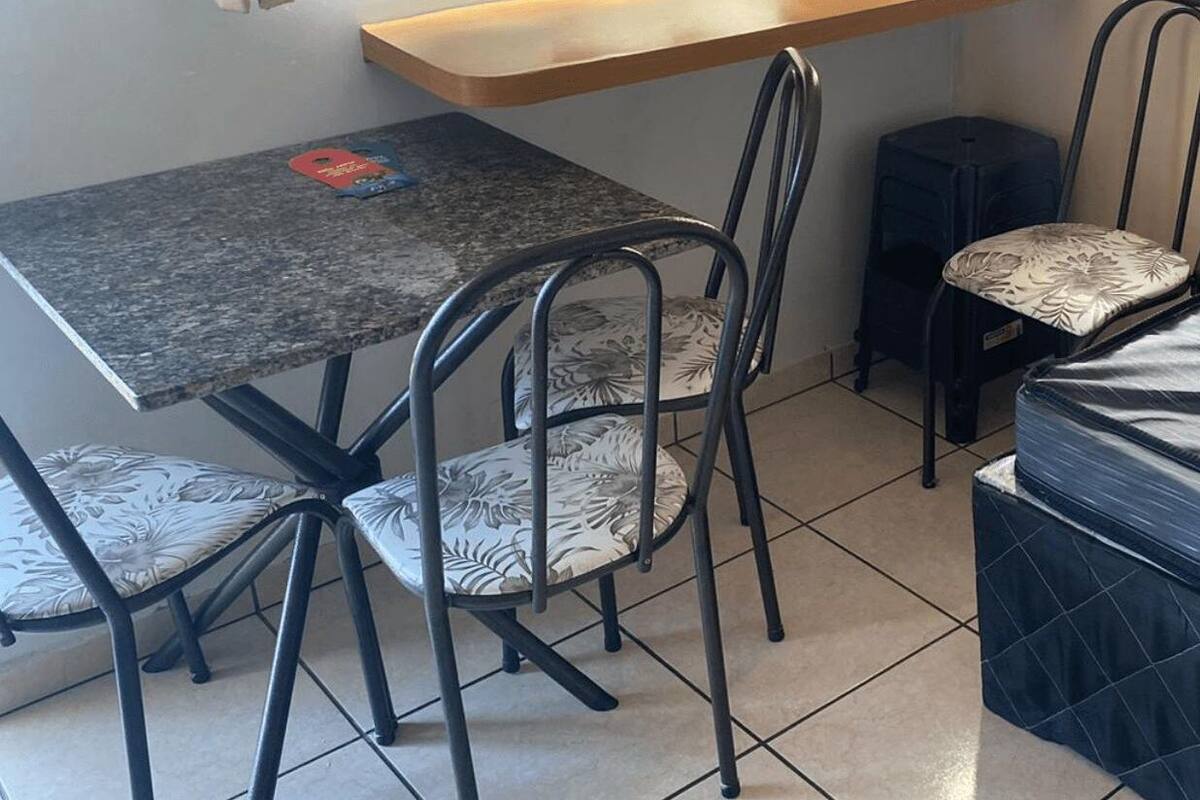 A small, compact room with a single bed, a small table, and two chairs.