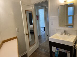 Een bad/douchecombinatie, een haardroger, handdoeken, zeep