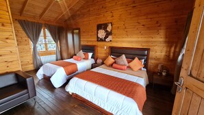 A wooden cabin room with two beds, a sofa, and a painting on the wall. - Cabañas & Mirador Secret Garden Costa R. (Potrero Cerrado)