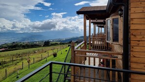 A wooden building with a balcony overlooking a vineyard. - Cabañas & Mirador Secret Garden Costa R. (Potrero Cerrado)