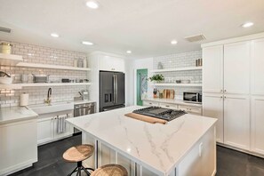 Enjoy cooking in this well-equipped kitchen with a central island, stove, and ample counter space.