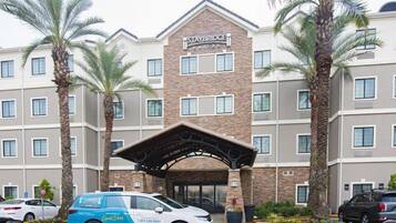 A Staybridge hotel with a stone facade, multiple windows, and a covered entrance.