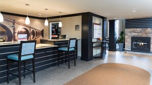 A reception area with a bar, seating, a fireplace, and a mural. - Fully-Equipped Suite | Complimentary Breakfast (Oakbrook Terrace)