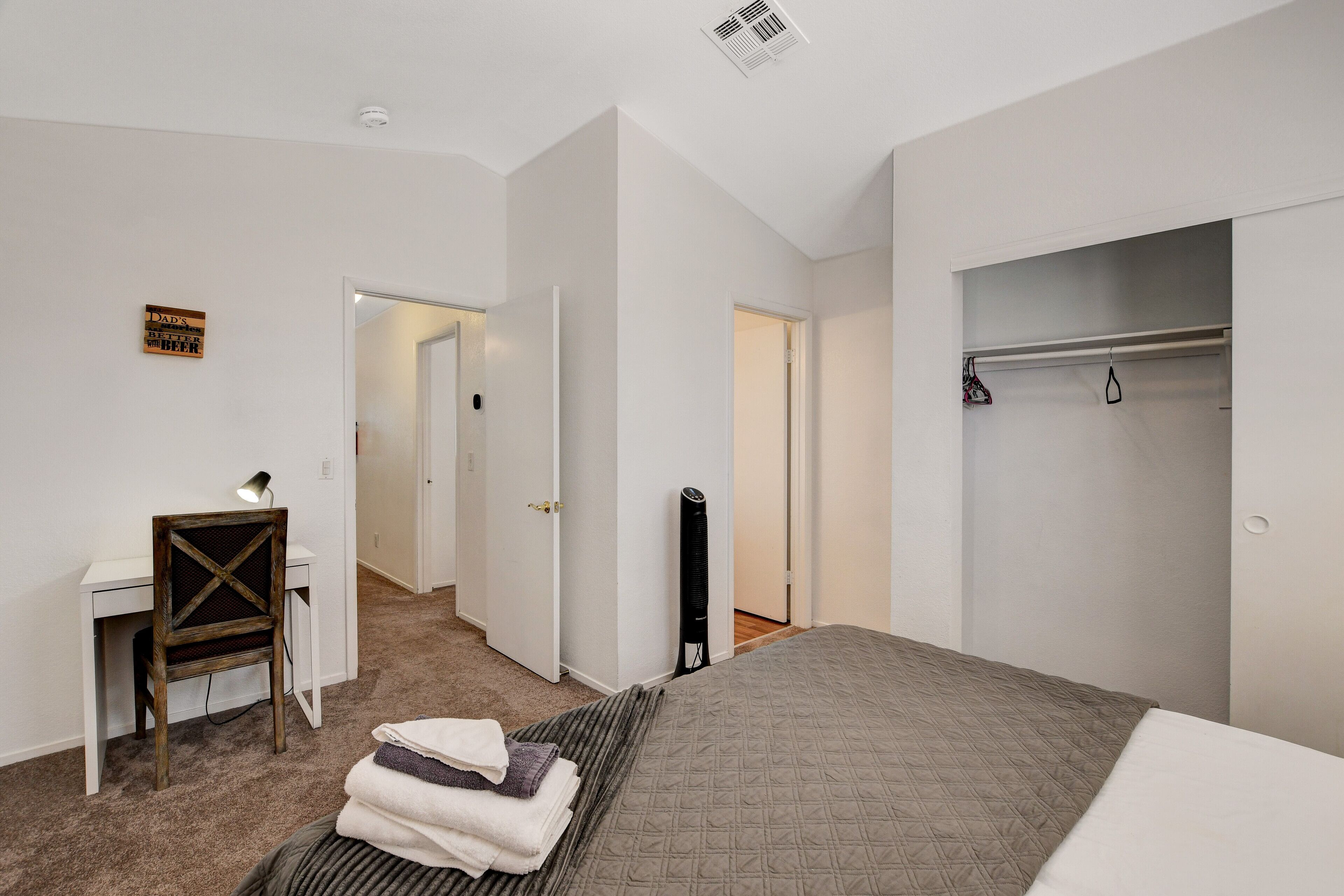 A bedroom with a bed, a desk, a chair, a wardrobe, and a radiator.