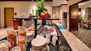 Ein reichhaltiges Buffet mit verschiedenen Speisen, darunter Müsli, Obst und einer Salatbar.