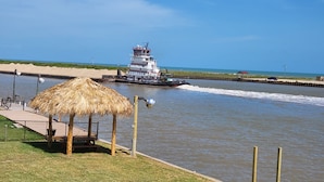 Un río con una barca, una construcción de techo de paja y una playa arenosa.