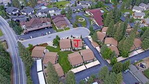 An aerial view of a residential area with houses, roads, and a large 'T' marked building.