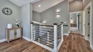 A modern interior with a staircase, wooden flooring, and a clock on the wall. - Mountain Base Camp: Hot Tub, A/C, Dog Friendly (South Lake Tahoe)