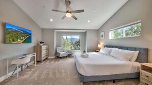 A bedroom with a bed, desk, chair, and a large window. - Mountain Base Camp: Hot Tub, A/C, Dog Friendly (South Lake Tahoe)