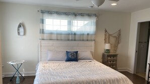 A bedroom with a bed, a ceiling fan, a nightstand, and a window with curtains. - Mermaid Place is only 5 min walk to the beach. (Seaside Heights)