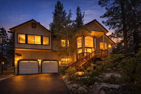 A two-story house with a garage, a staircase, and a deck.