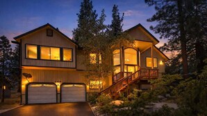 A two-story house with a garage, a staircase leading to a balcony, and a driveway.