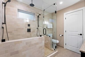 A modern bathroom with a glass-enclosed shower, a toilet, and a white door. - Tahoe Treehouse: Hot Tub, Near Northstar, Views (Tahoe Vista)