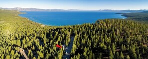 A forested area with a clear view of a lake and mountains in the distance. - Tahoe Treehouse: Hot Tub, Near Northstar, Views (Tahoe Vista)