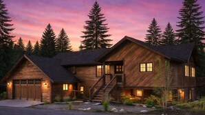 Ein zweigeschossiges Holzhaus mit Garage, Treppe und Auffahrt.