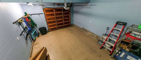 Een garage met een houten deur, gereedschap en een werkbank.