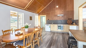 A modern kitchen with wooden cabinets, a built-in oven, and a sink. - Hidden Valley Getaway (Martinborough)