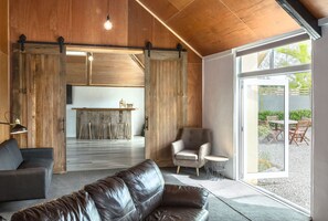 A modern interior with a leather sofa, a wooden dining area, and a sliding barn door.