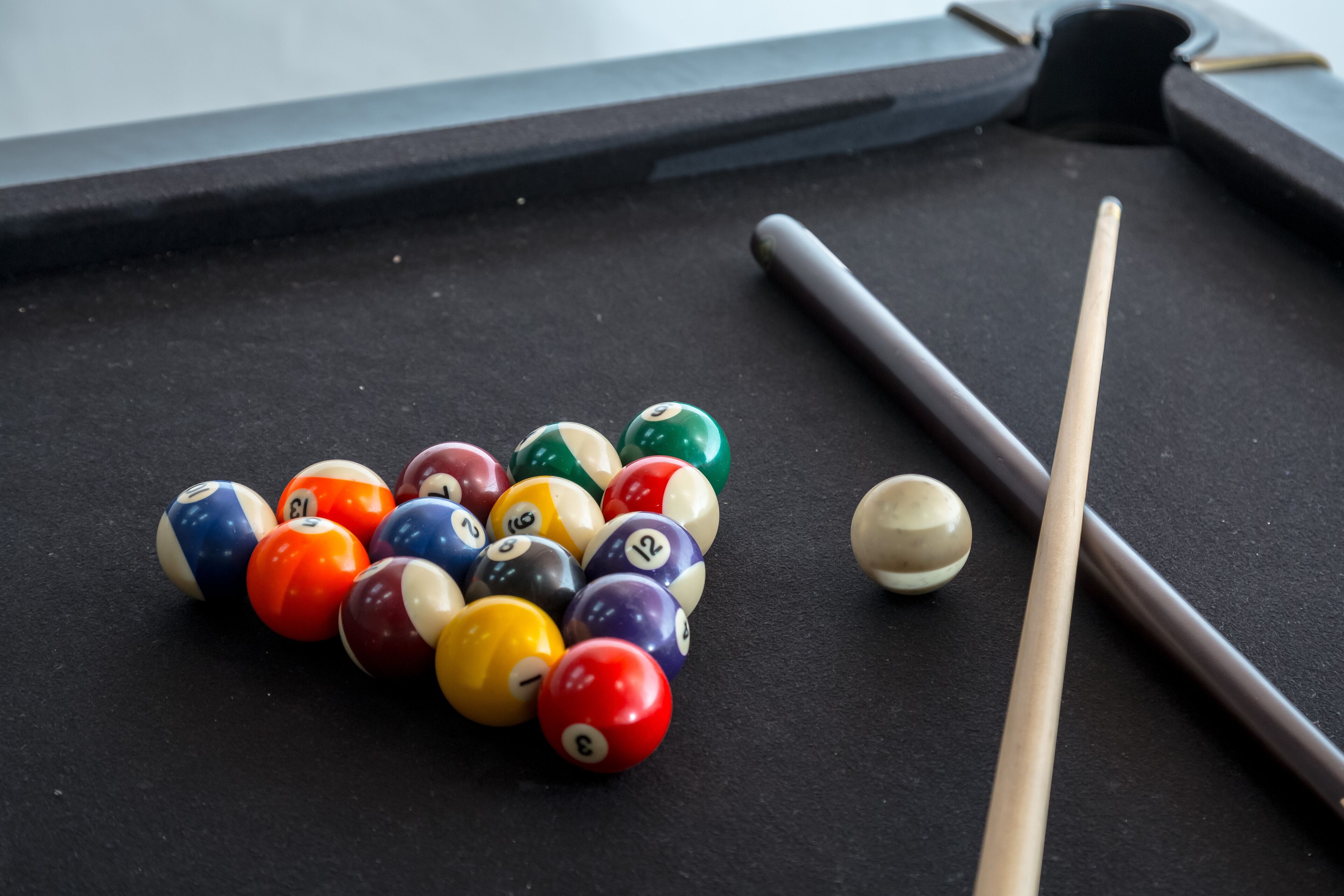 A pool table with billiard balls and cues.