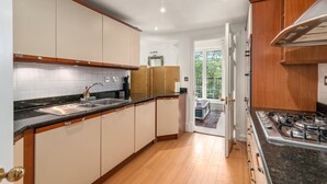 Una cucina moderna con mobili in legno, un piano di lavoro nero e un fornello a gas.