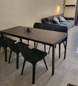 A dining area with a rectangular table and four black chairs. - Paphos town house vacation (paphos)