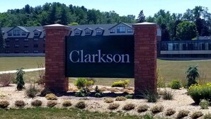 Un panneau portant le nom « Clarkson », placé dans un espace aménagé avec un bâtiment en arrière-plan.