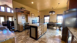 Una cocina amplia con una isla central, armarios de madera y un refrigerador grande.