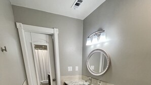 Ein Badezimmer mit Toilette, Waschbecken, Spiegel und Mülleimer.