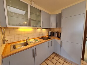 A kitchen with a sink, microwave, and cabinets.