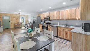 A modern kitchen with wooden cabinets, stainless steel appliances, and a granite countertop. - Relaxing, family friendly lodge by the lake. (Ten Mile)