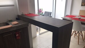 A modern kitchen with a central island, a sink, and a dining area with a table and chairs. - SPA BEACH HOUSE con PLAYA PRIVADA/PISCINA/JACUZZI (Manta)