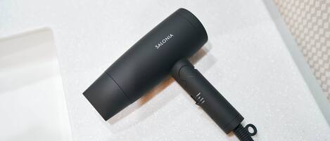 A black portable charger with the brand name 'SALONIA' on it, lying on a white textured surface.