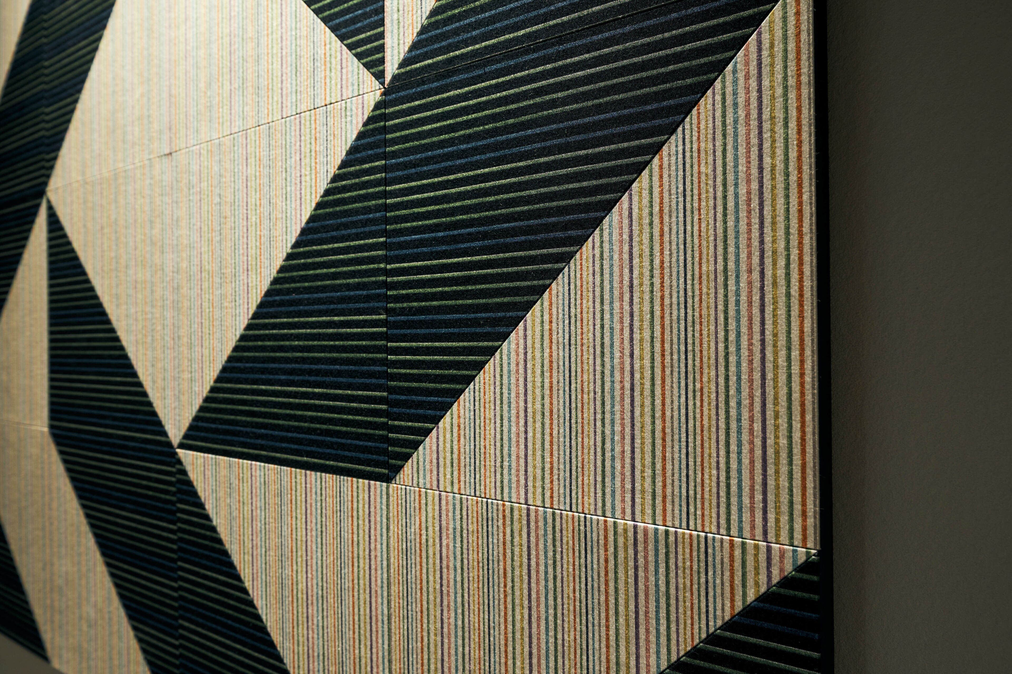 A geometric patterned wall with a mix of striped and solid tiles.