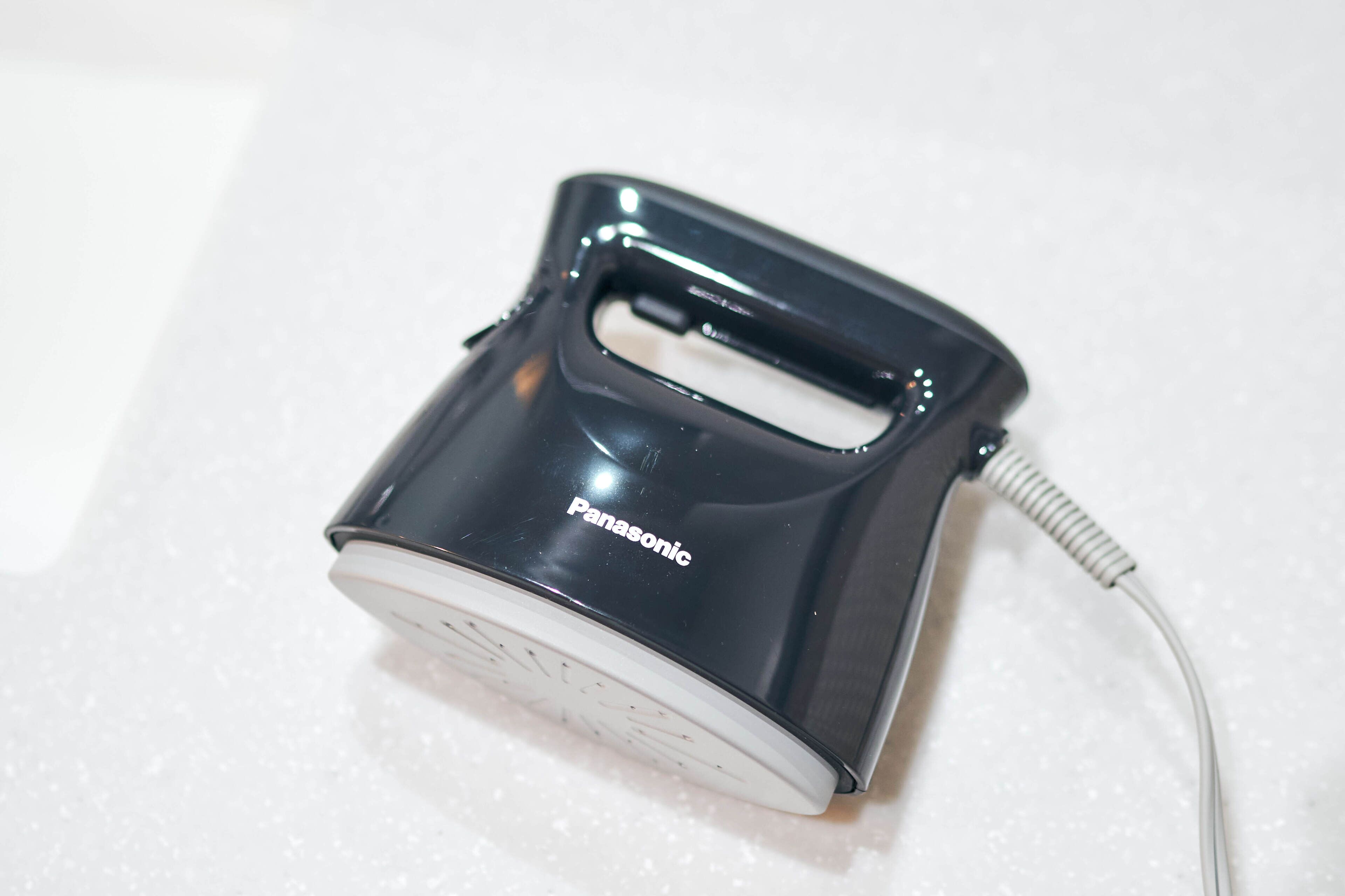 Un electrodoméstico Panasonic con asa y cable.