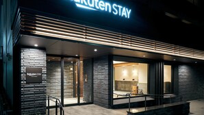 A modern building with a sign reading "Rakuten Stay" and a glass entrance. - Rakuten STAY Kokura Station (Kitakyushu)