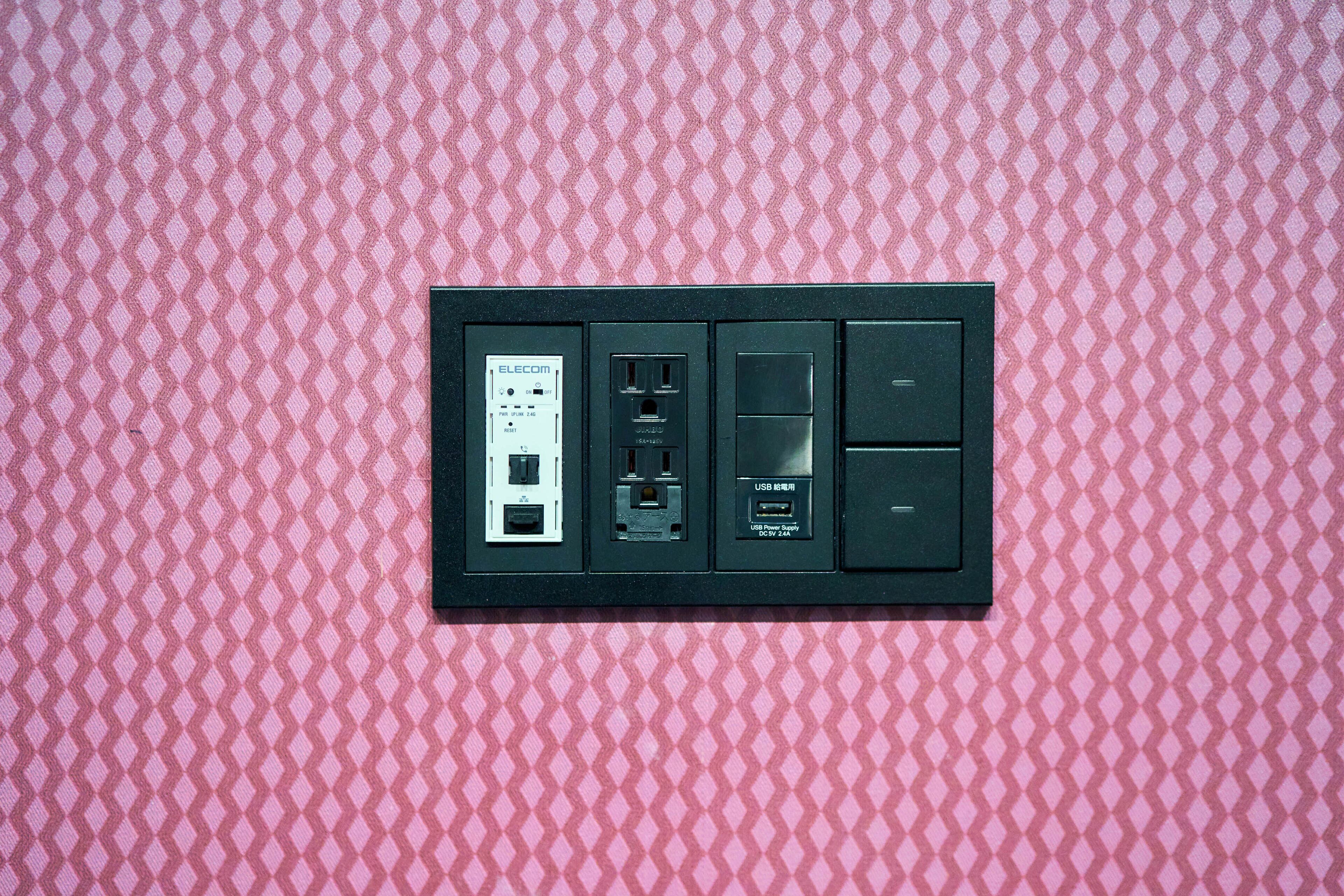 Un panneau électrique mural doté de plusieurs prises et de ports USB.