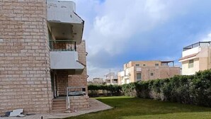 Een woongebouw met een bakstenen gevel, een plat dak en een klein balkon.