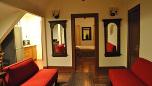 A room with two red sofas, a wooden coffee table, and a mirror on the wall. - Newark Hansbury Multi Level House (Newark)