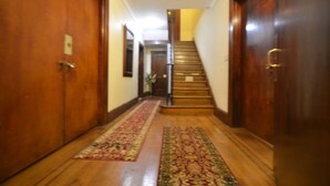 A hallway with wooden doors, a staircase, and a red carpet. - Newark Hansbury Multi Level House (Newark)