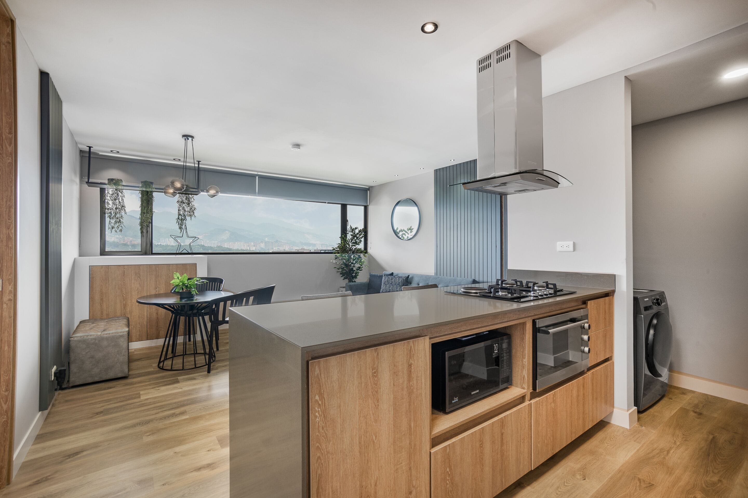 Eine moderne Küche mit einer großen Kochinsel, integriertem Backofen und Blick auf die Stadt.