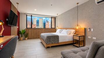 Un dormitorio moderno con cama, mesita de noche y escritorio con silla.