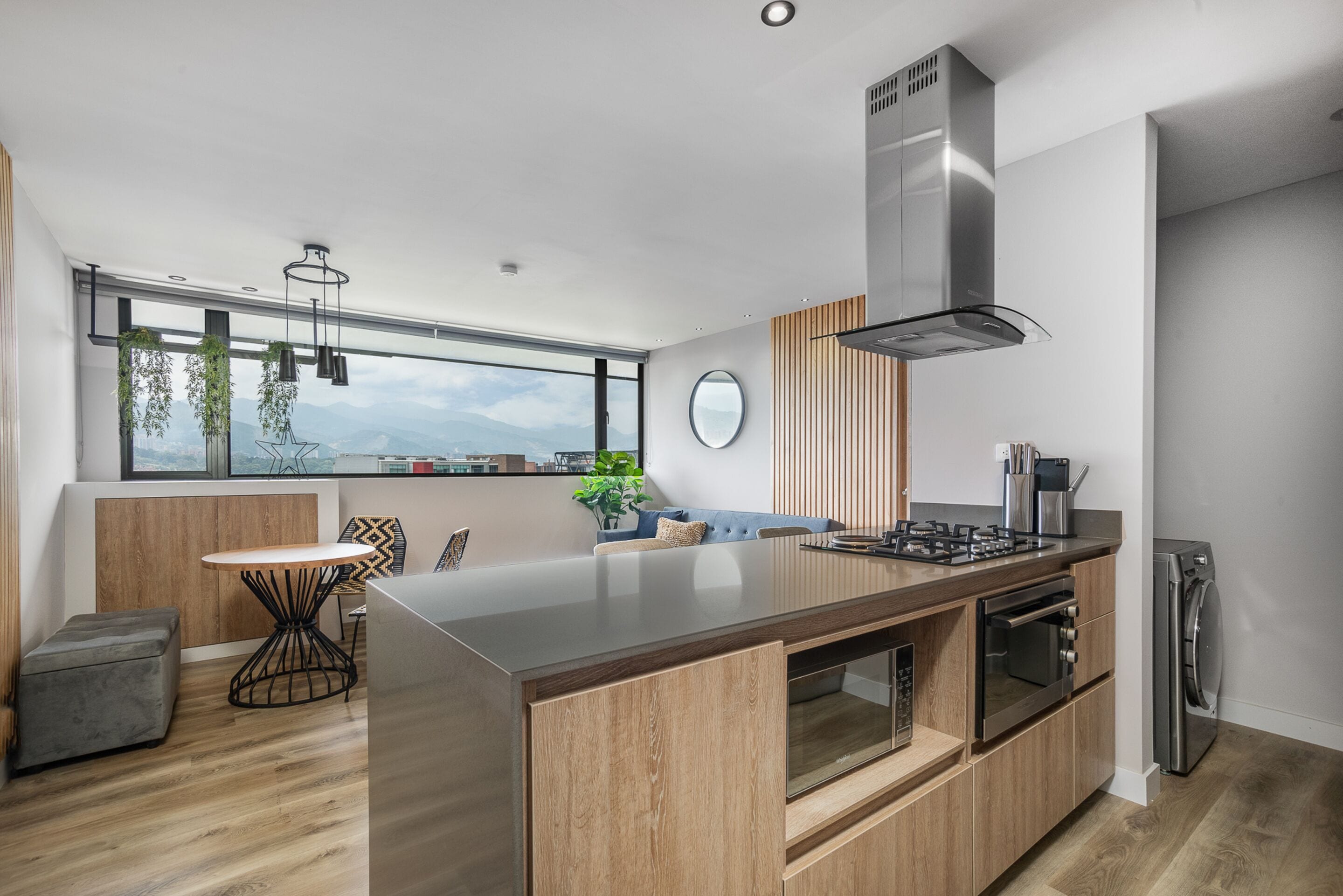 A modern kitchen with a central island, built-in oven, and stainless steel appliances.
