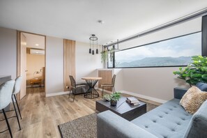 Een moderne woonkamer met een bank, salontafel en eethoek.